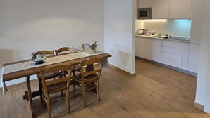 Moderni keittiö, jossa on valkoiset kaapit, mikroaaltouuni ja pesuallas.