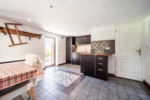 A kitchen with dark cabinets, a white door, and a checkered tablecloth.