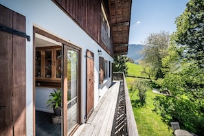 Un edificio de madera con un balcón que da a un paisaje verde.
