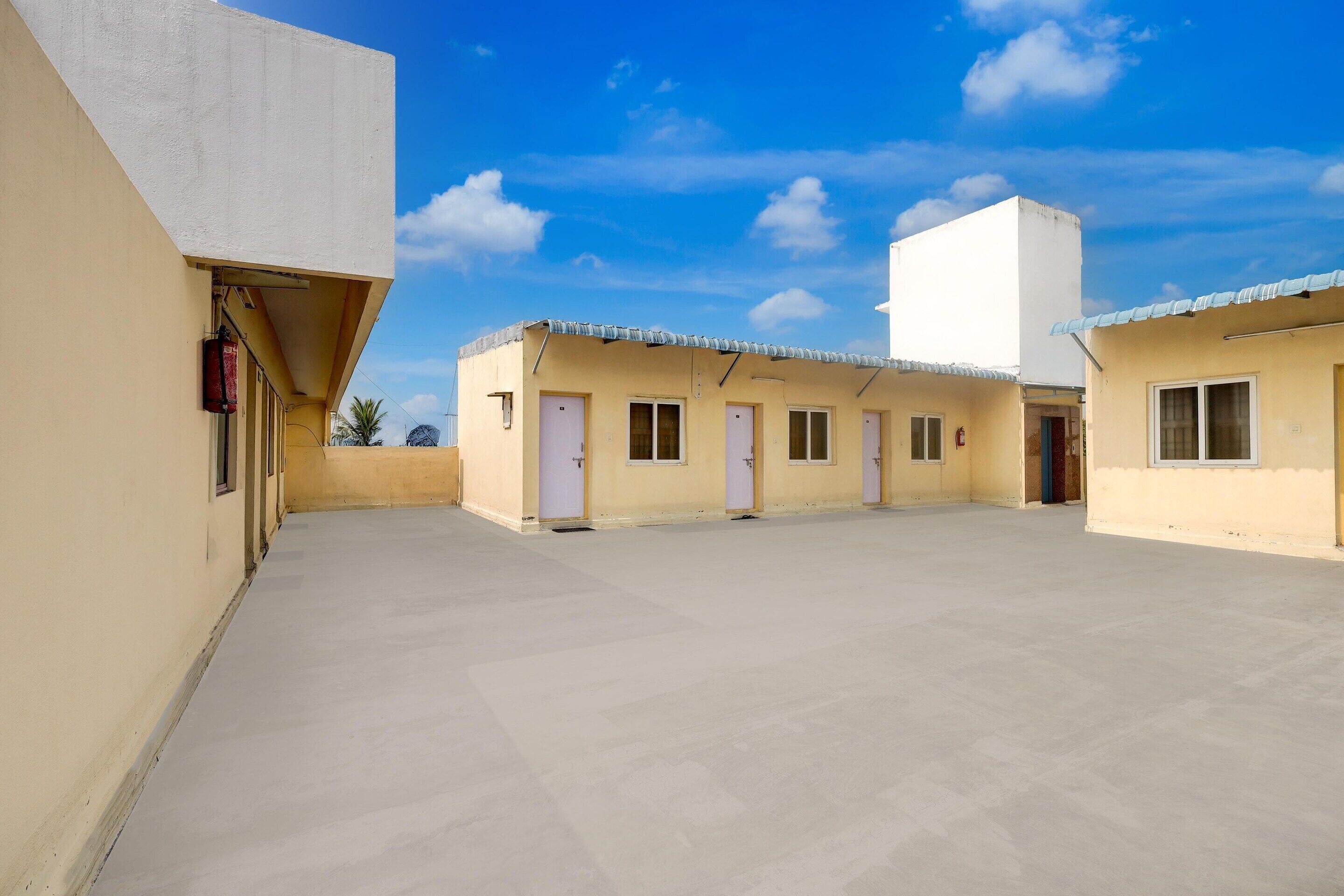A courtyard with a flat roof, multiple doorways, and a clear sky.