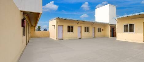 A courtyard with a flat roof, multiple doorways, and a clear sky.