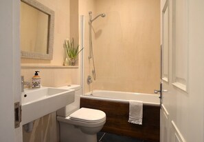 Une salle de bain avec des toilettes, un lavabo et une douche.