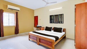 A bedroom with a bed, a desk, an air conditioner, a ceiling fan, and a wardrobe. - Deluxe BV Stayz (Chennai)