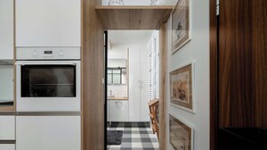 Una cocina con horno empotrado, suelo de cuadros y cuadros en la pared.