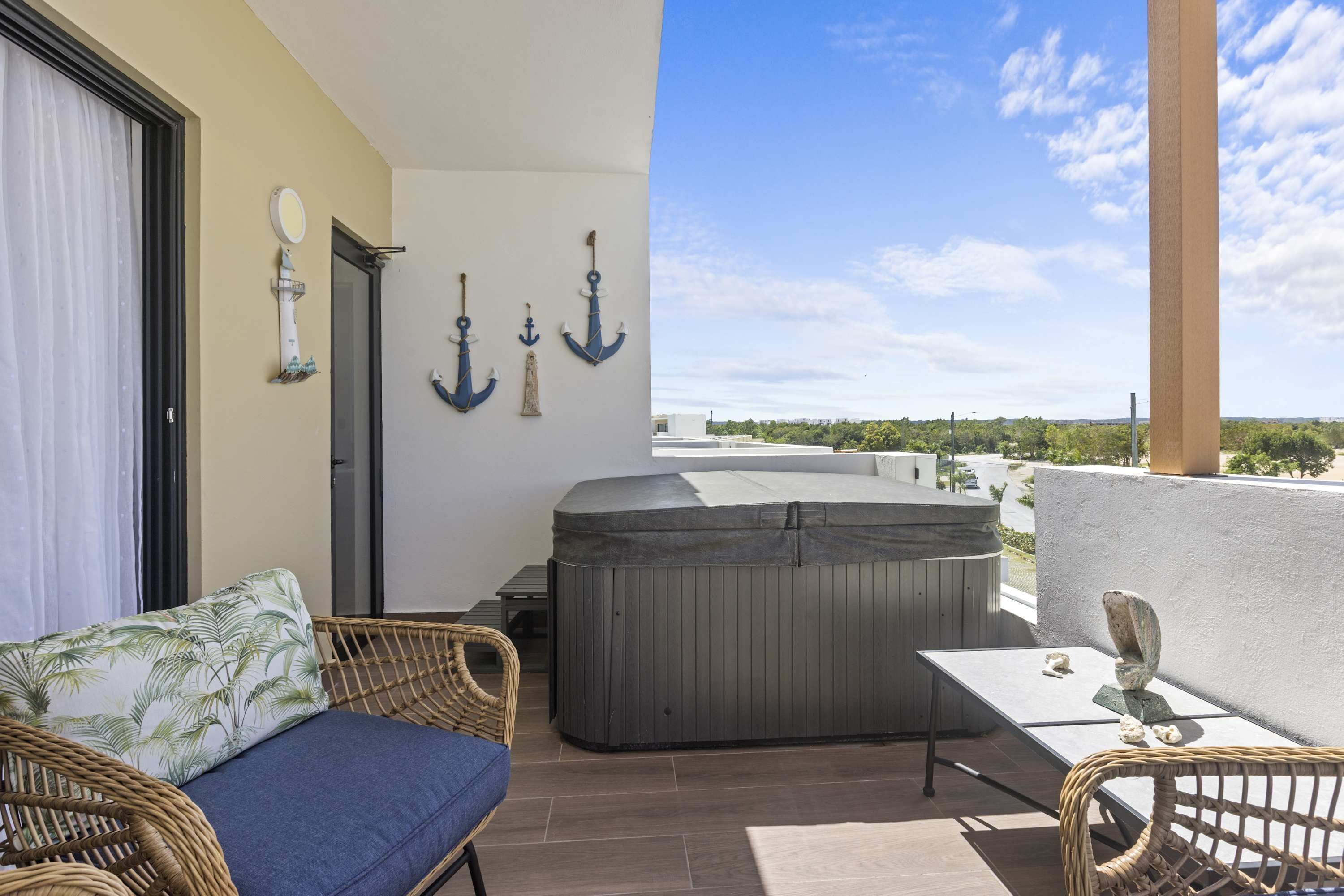 A balcony with a sofa, a hot tub, and decorative anchors.
