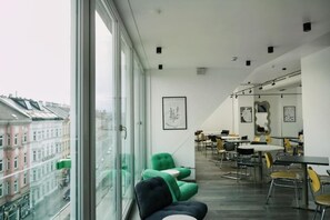 Ein modernes Interieur mit großen Fenstern, einem Essbereich und Blick auf Gebäude.