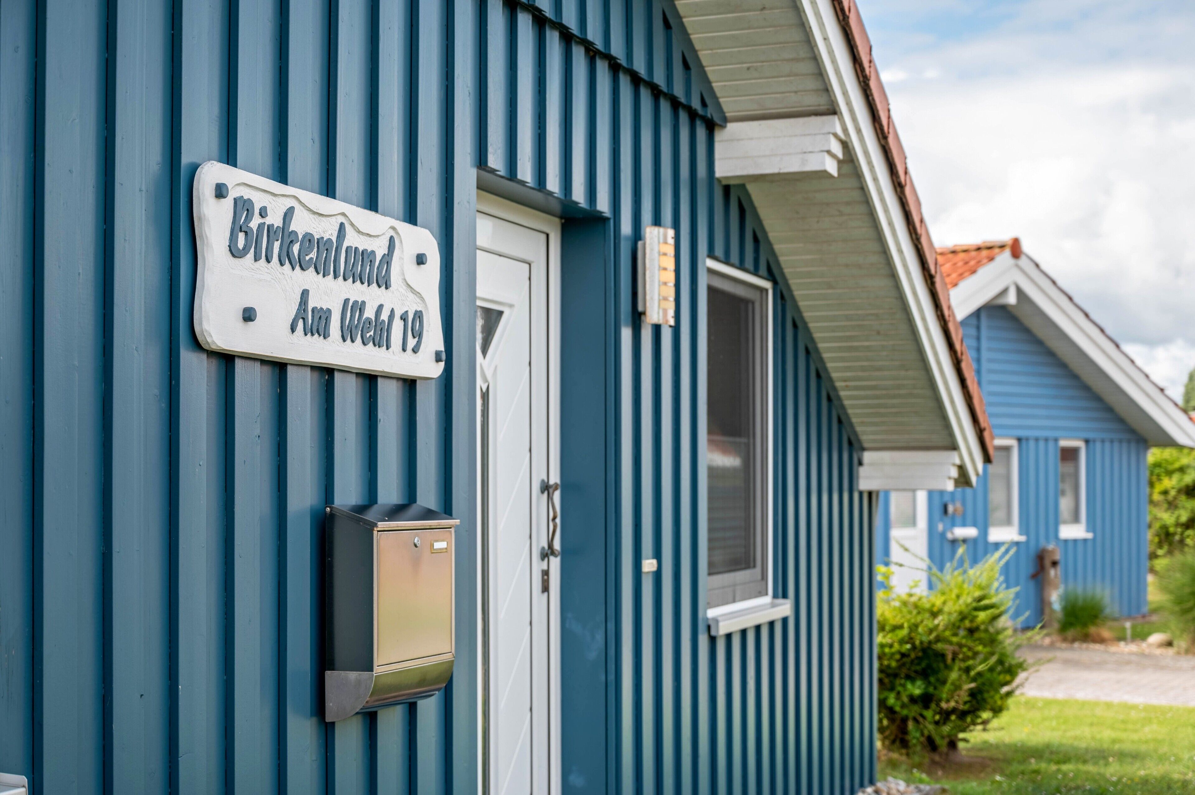 En blå bygning med et skilt, der siger 'Birkenlund Am Weil 19'.