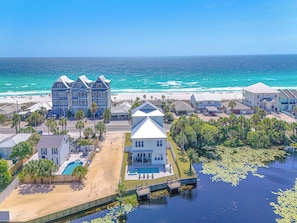 Un quartier résidentiel situé sur la côte, avec des maisons, une plage et une piscine.