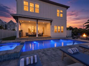 Une maison à deux étages dotée d’une piscine, d’un espace salon extérieur et d’un patio.