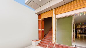 Um edifício moderno com uma escadaria que leva a uma entrada com porta de vidro.
