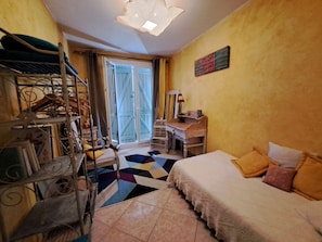 Une chambre avec un lit, un bureau, une chaise et une fenêtre donnant sur un beau paysage.
