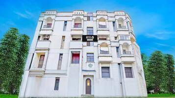 A multi-story hotel with a prominent 'HOTEL' sign, arched windows, and a central entrance.