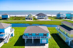 Une zone résidentielle côtière comprenant plusieurs maisons, un petit plan d’eau et une plage en arrière-plan.