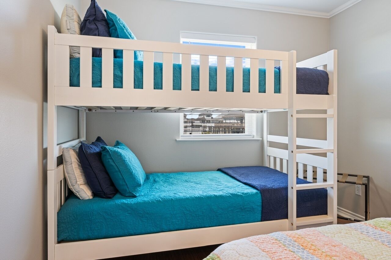 Una cama litera con una ventana sobre la cama inferior.