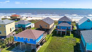 A coastal residential area with houses, a beach, and a clear sky. - Crystal Blue 3 Bedroom Home (Port Bolivar)