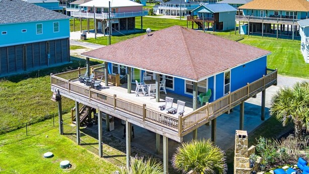 A coastal house with a deck, a covered patio, and a view of the ocean. - Crystal Blue 3 Bedroom Home (Port Bolivar)