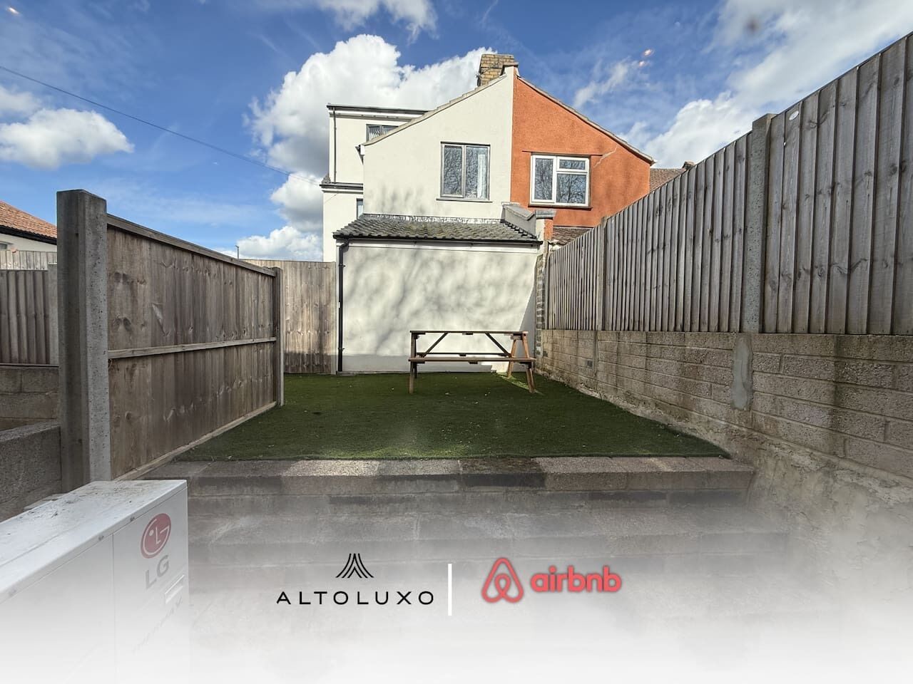 A residential property with a fenced backyard, a bench, and a visible house in the background.