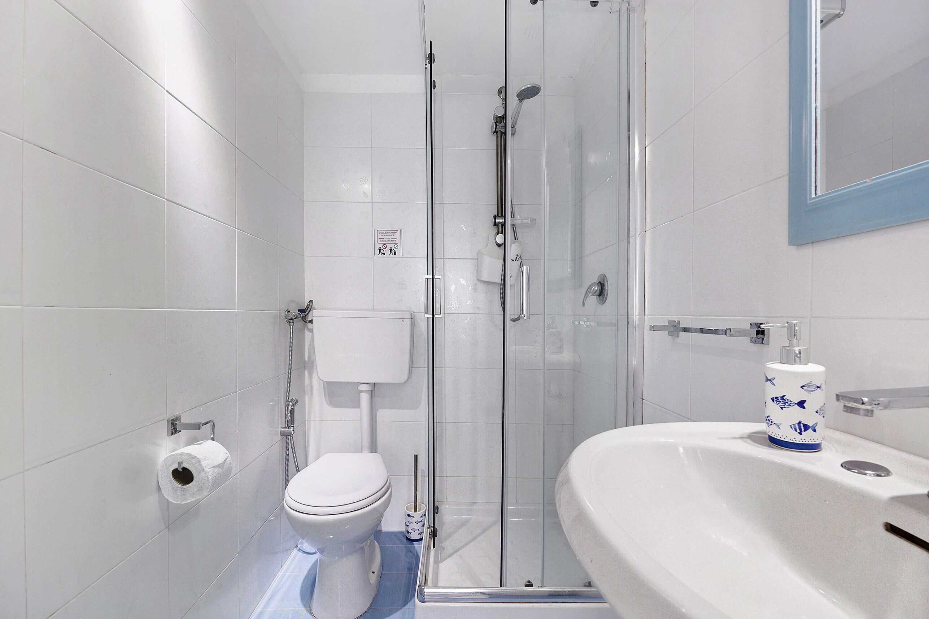 Une salle de bain comprenant des toilettes, un espace douche et un lavabo.