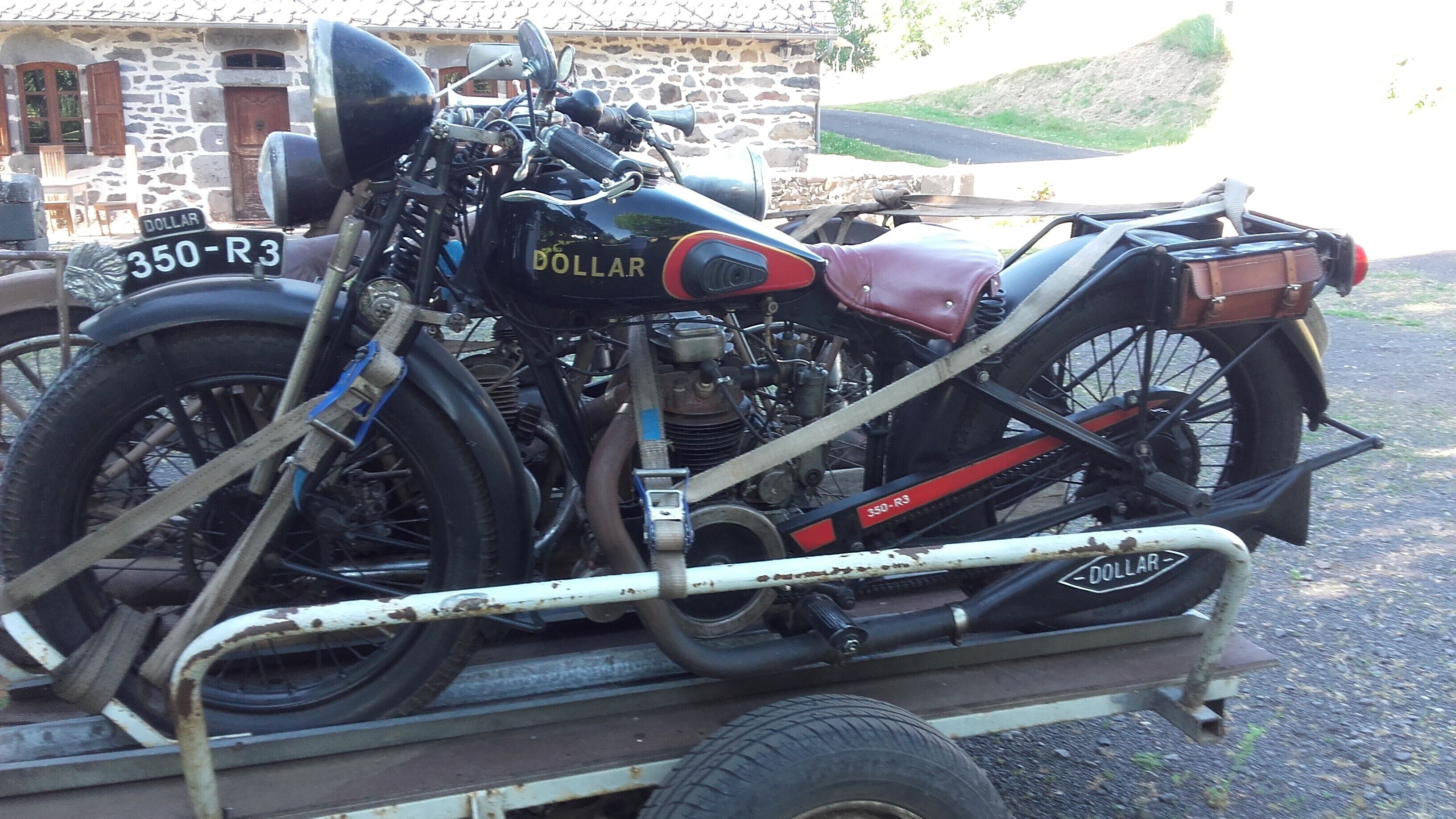 Eine klassische Motorrad mit Beiwagen, beschriftet mit '350-R3', auf einem Anhänger abgestellt.