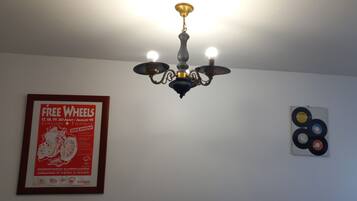 Un lustre à trois lampes, une affiche encadrée accrochée au mur et une œuvre d’art murale représentant un disque vinyle.
