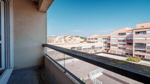 A balcony with a view of a residential area, featuring multi-story buildings and a clear sky. - Small studio for 2 people, close to amenities (Agde)