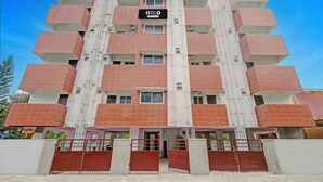 A multi-story hotel with a prominent 'HOTEL' sign, multiple balconies, and a gated entrance. - Deluxe tad Homes (Sriperumbudur)