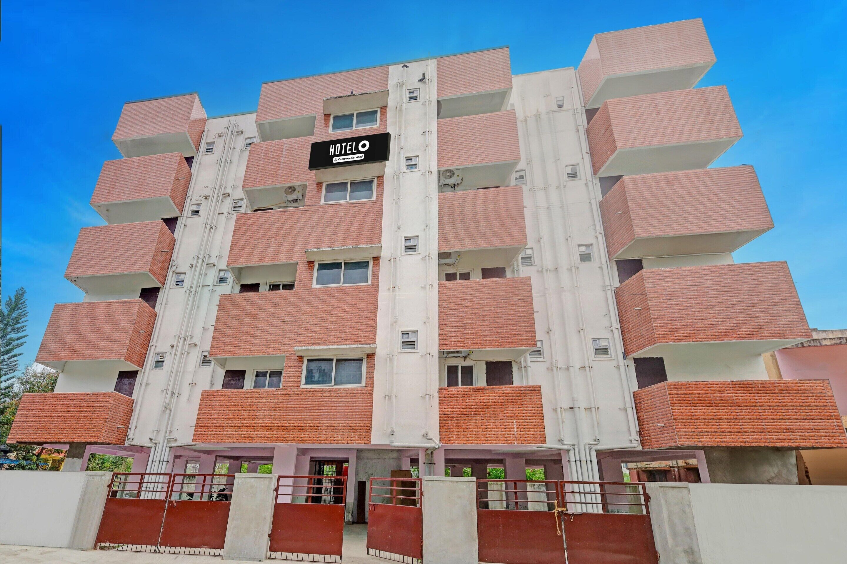 Un hotel de varios pisos con un letrero que dice 'HOTEL' y balcones en cada planta.