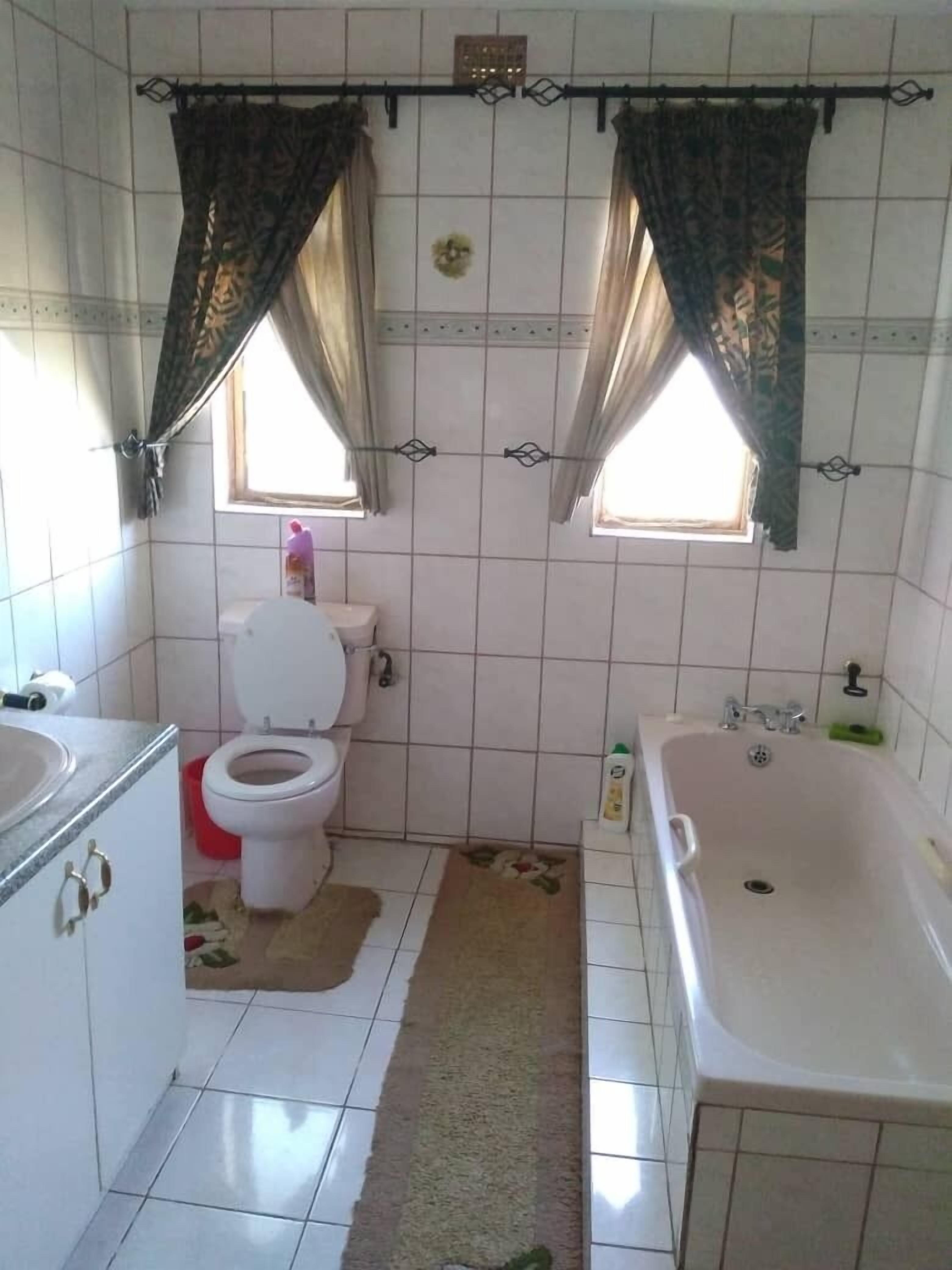 Une salle de bain avec des toilettes, un lavabo et une baignoire.