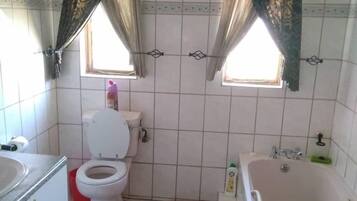 Une salle de bain avec des toilettes, un lavabo et une baignoire.