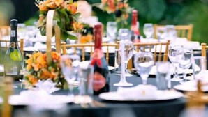 A table set for a formal event with a black tablecloth, wine glasses, and floral centerpieces. - Green Oasis Lodges (Harare)