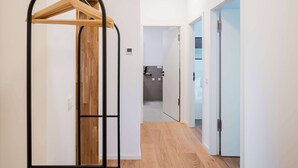 Ein Flur mit einem Holzaufhänger, einer Tür und Blick ins Badezimmer.