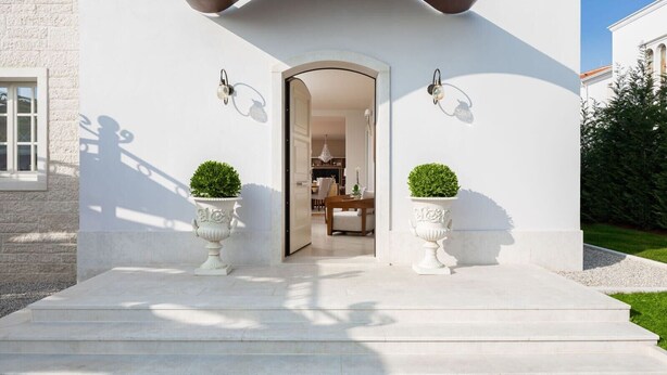 A modern house with a white exterior, a covered entrance, and two potted plants on either side. - Villa Fiordaliso – Luxury villa for up to 6 guests with private pool in peaceful Mediterranean surroundings. (Vabriga)