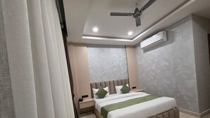 Una camera da letto con un letto, comodini, un condizionatore d'aria e una ventola a soffitto.