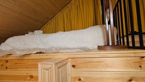 A wooden cabin interior with a bed, a wooden railing, and a yellow curtain. - Mood villa kazbegi is city centre of Stepantsminda, with mountimes view. For you (Stepantsminda)