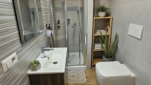 A modern bathroom with a shower, a sink, a toilet, and a mirror. - ARYA Cagliari (Cagliari)