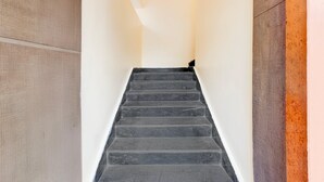 A staircase with a textured wall on one side and a plain wall on the other.