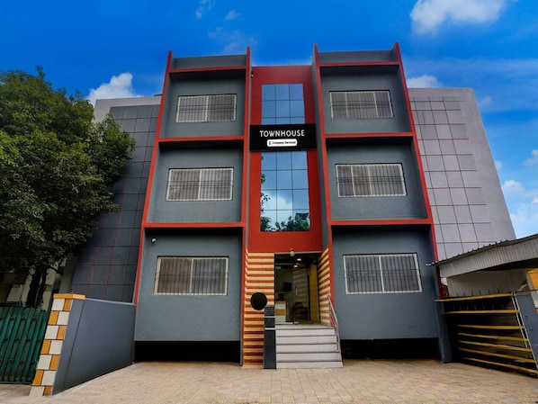A multi-story building with a sign reading 'TOURNHOUSE Company Serviced.'