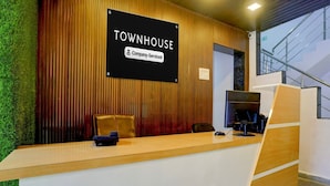 A reception desk with a sign reading 'TOWNHOUSE Company-Serviced.' - Deluxe Seven Hills Aurangabad (Chhatrapati Sambhajinagar)