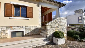 Ein Gebäude mit Steinwänden, einem Kamin und einer Treppe, die zu einer Holterrasse führt.