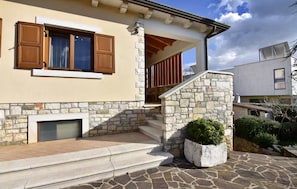 Ein Gebäude mit Steinwänden, einem Kamin und einer Treppe, die zu einer Holterrasse führt.