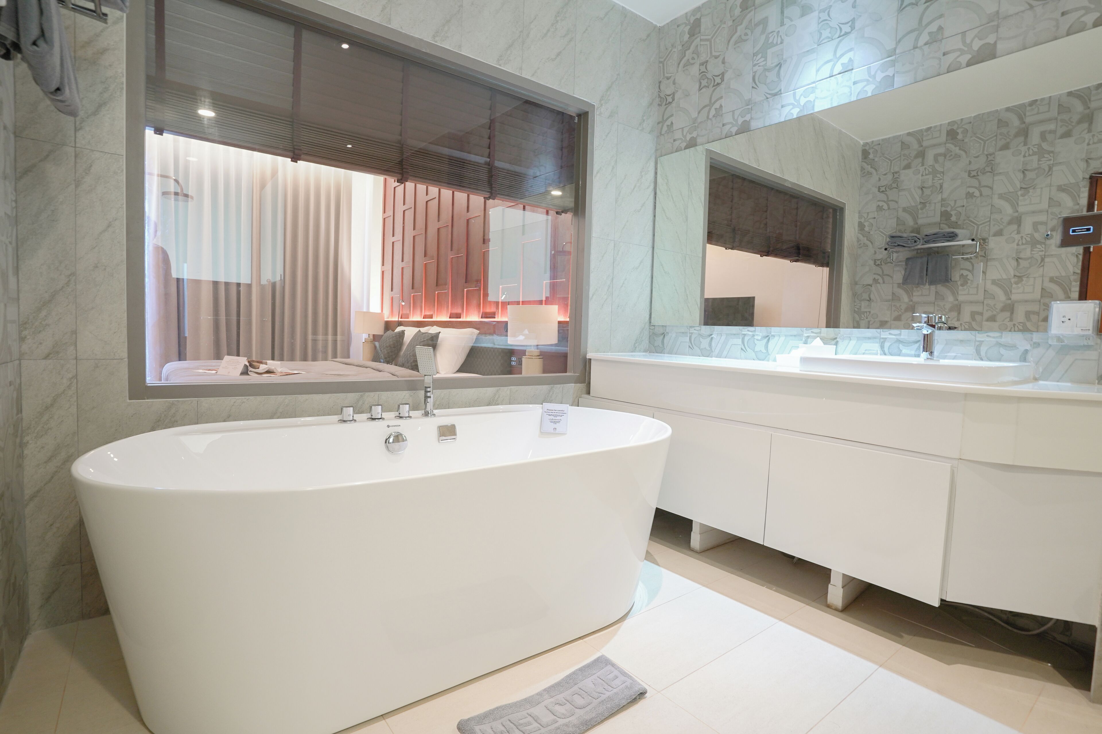 Ein modernes Badezimmer mit einer freistehenden Badewanne, einem großen Spiegel und einem Waschtisch.