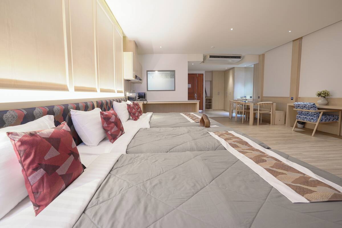 Hotellihuone, jossa on suuri sänky, työpöytä ja ruokailutila.