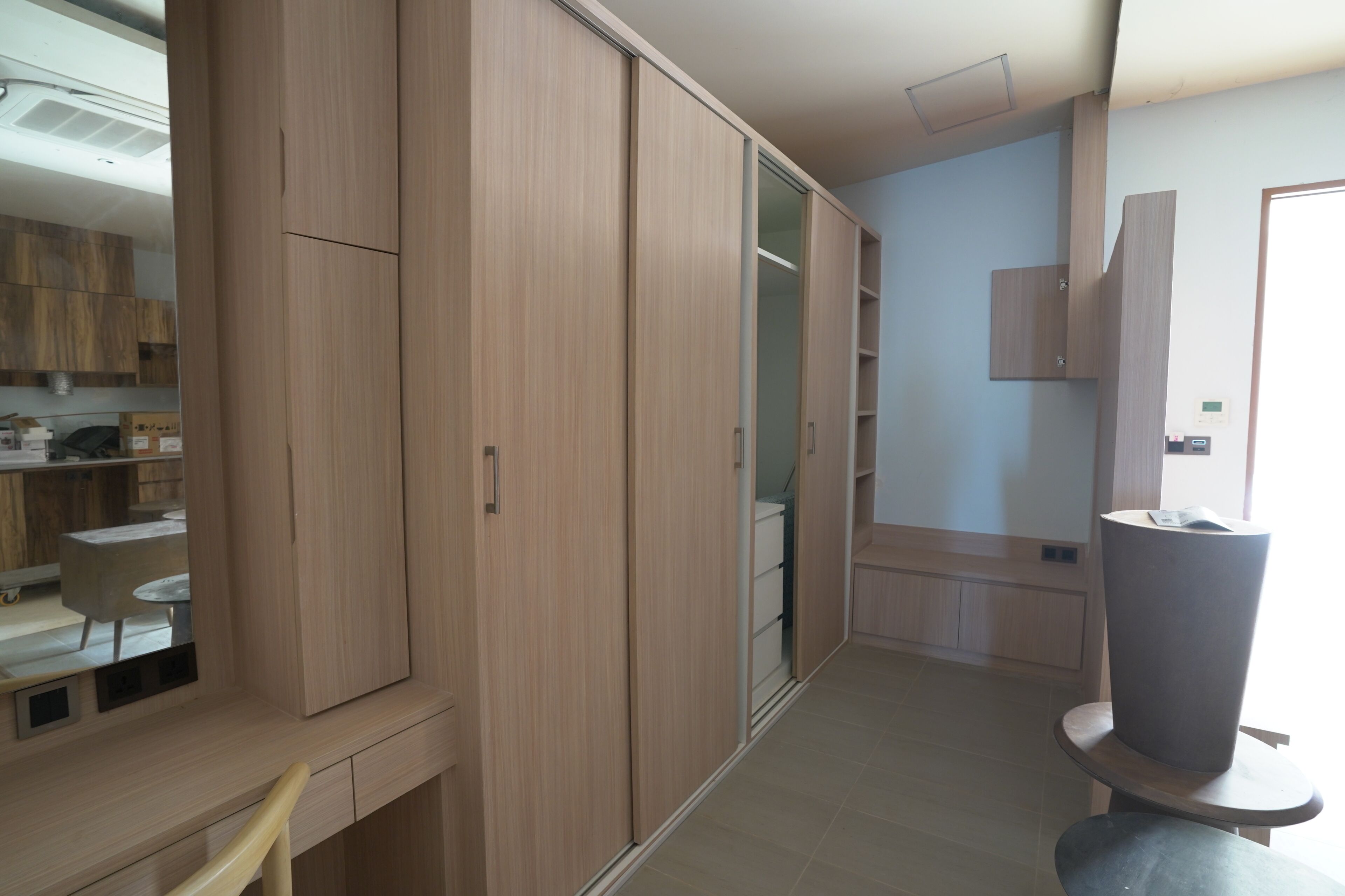 Una habitación moderna con un armario de madera, un escritorio y una silla.
