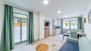 A modern apartment with a kitchen, dining area, and living room.