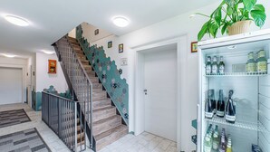A staircase with a unique design, a refrigerator stocked with beverages, and a door leading to another room.