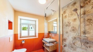 A bathroom with a toilet, sink, and shower.