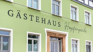 Un bâtiment dont la façade porte l’inscription « Gästehaus Hopfenperle ».