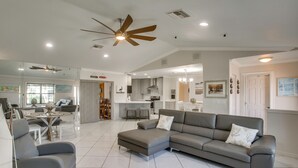 A spacious living area with a grey sectional sofa, a dining table, and a ceiling fan. - 3 Mi to Sun Splash Waterpark! Family Haven w/ Pool (Cape Coral)