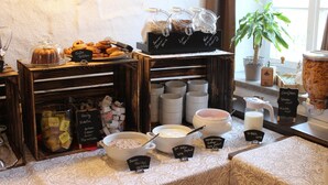 A buffet with various food items and containers, including a section labeled 'HONEY Nutella' and another with 'Berries.' - Double room Hotel-Garni (Heidenheim)
