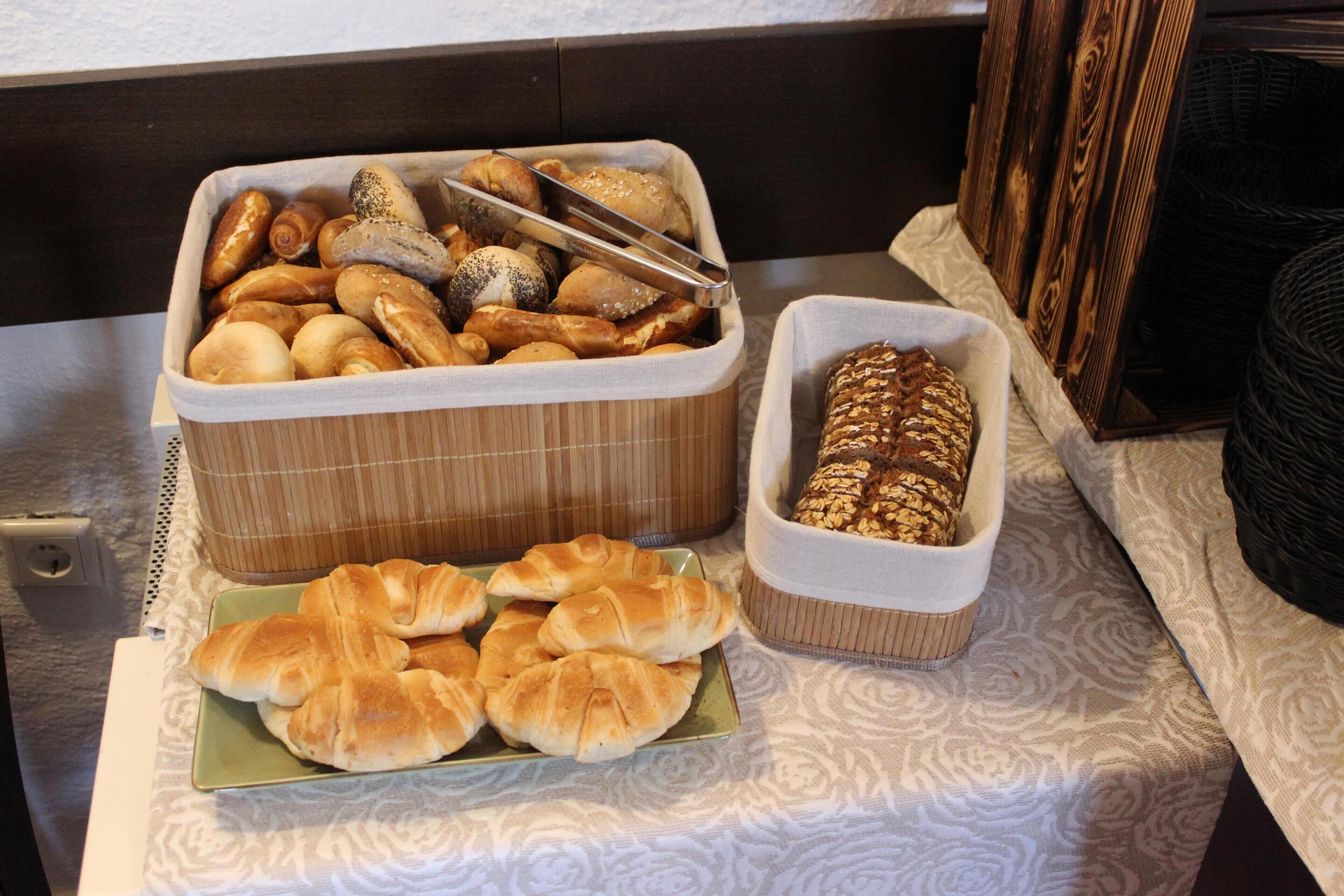 Un bufé con diversos productos horneados, como pan, bollos y pasteles.